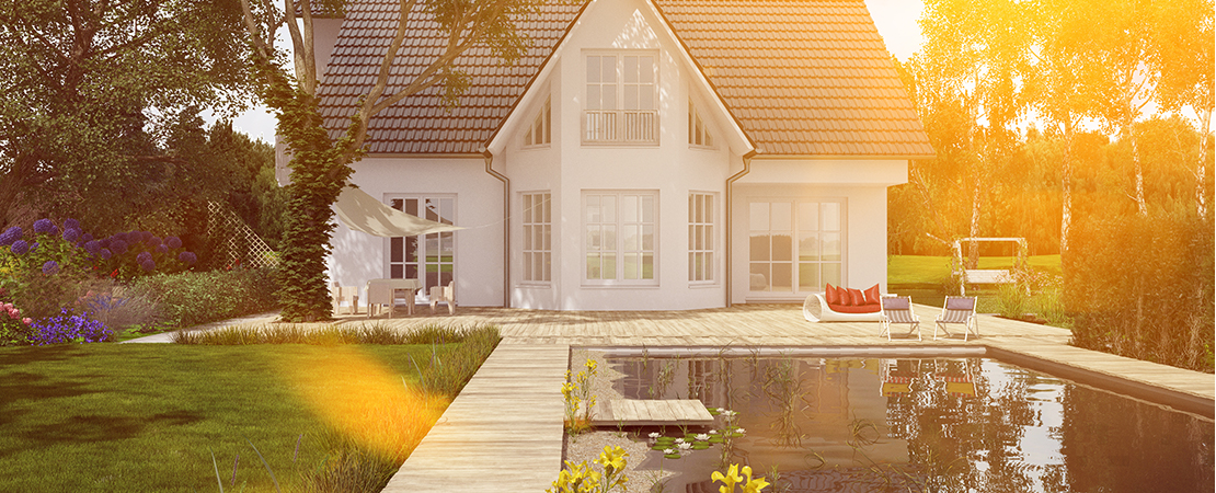 Modernes Einfamilienhaus mit Naturpool bei Sonnenuntergang – das Eigenheim als Kapital im Ruhestand.