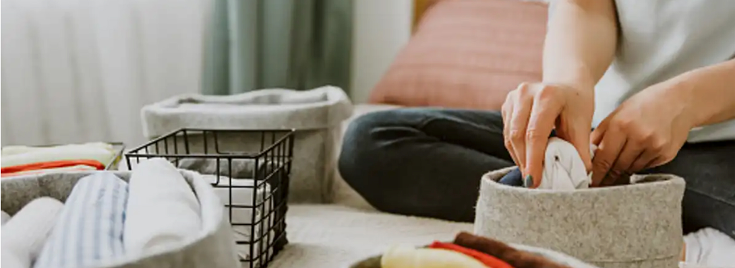 Ordnung schaffen mit System: Eine Person, die Kleidung ordentlich in Körbe einsortiert