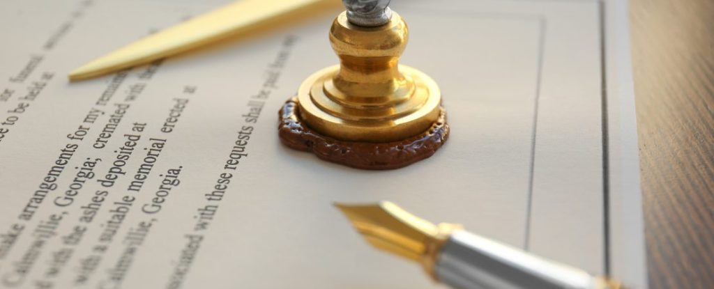 Detailaufnahme eines Notarstempels auf einer Urkunde, der ein rundes, erhabenes Wachsiegel zeigt.